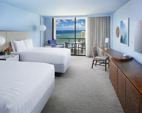 Two bed Ocean View room at Hyatt Regency Waikiki Beach Resort & Spa with desk and balcony.