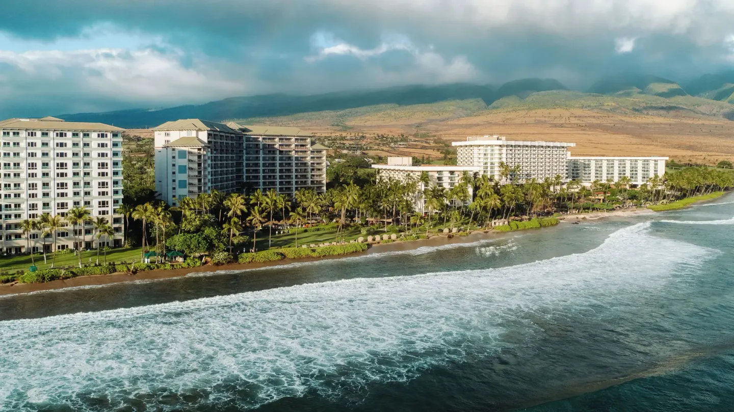 Coastal resort buildings with mountains behind Hyatt Vacation Club at Ka'anapali Beach.