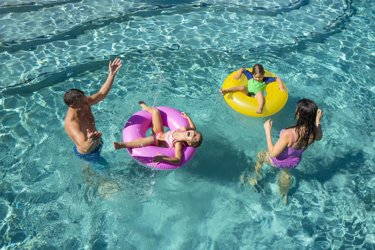 Family floating and playing in the pool at Hyatt Vacation Club at Ka'anapali Beach.