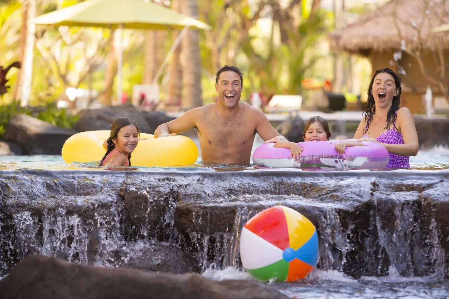 Family playing with inner tubes in the pool at Hyatt Vacation Club at Ka'anapali Beach.