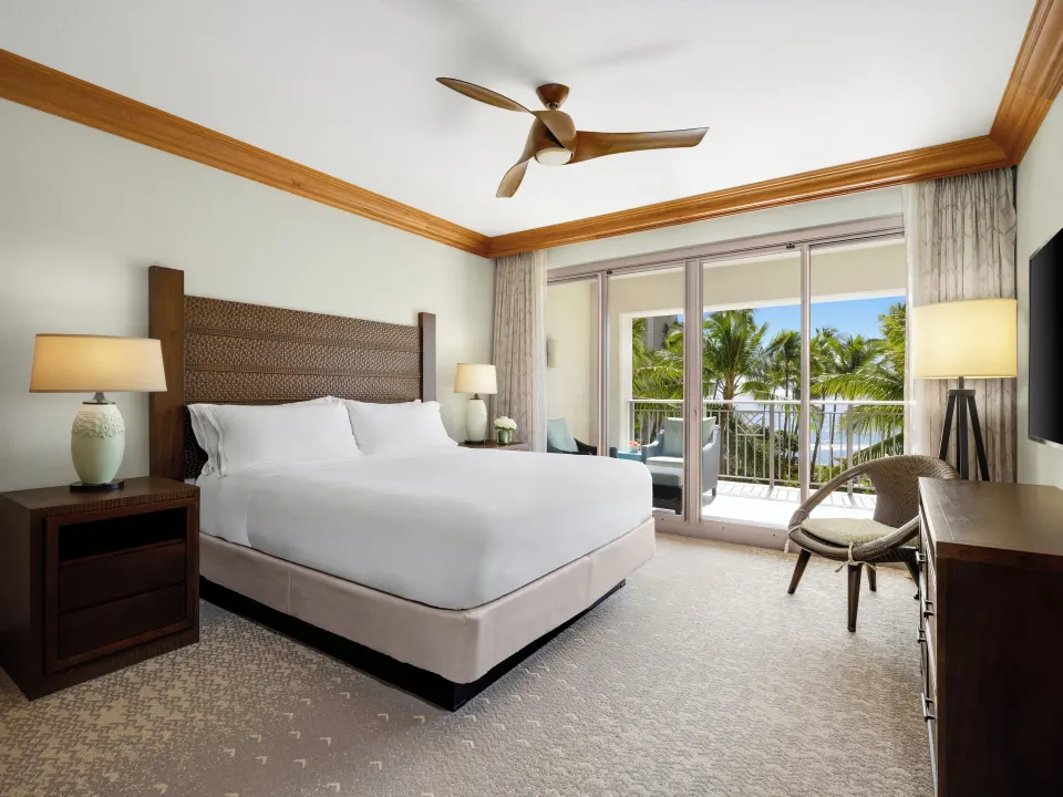 Guest room with king bed, balcony, and palm views at Hyatt Vacation Club at Ka'anapali Beach.