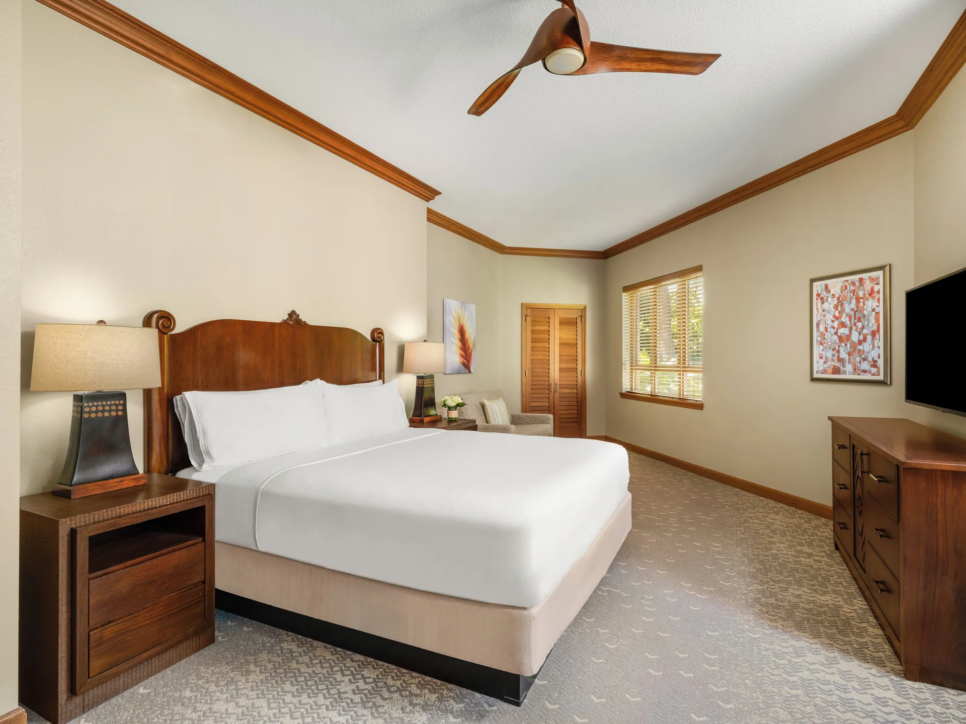 Guest room with king bed, wood furnishings, and shuttered window at Hyatt Vacation Club at Ka'anapali Beach.