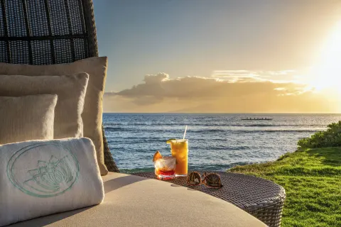 Oceanfront lounge chair with drinks at sunset at Hyatt Vacation Club at Ka'anapali Beach.