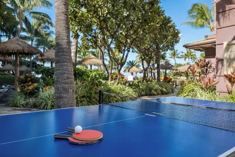 Blue ping-pong table with paddles amid palms at Hyatt Vacation Club at Ka'anapali Beach.