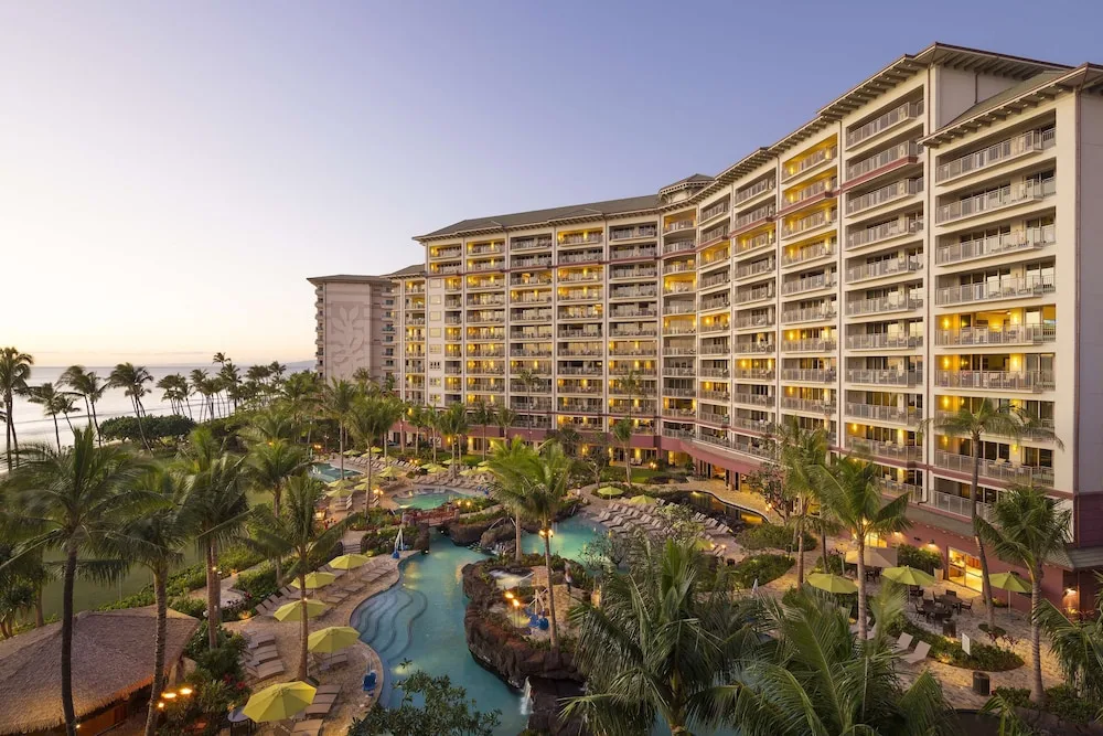 Resort tower, lagoon pool, palms, and ocean at dusk at Hyatt Vacation Club at Ka'anapali Beach.