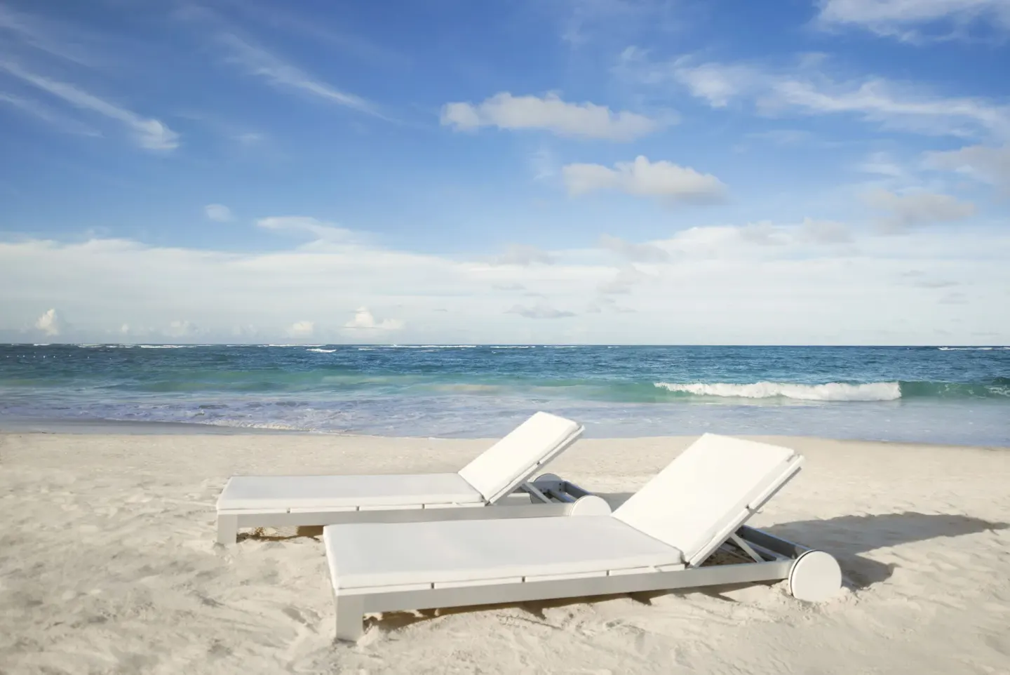 Two white loungers on the sandy beach at Iberostar Selection Bávaro Suites.