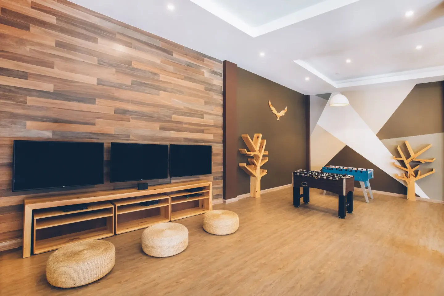 Game room with wall screens and foosball tables at Iberostar Selection Bávaro Suites.