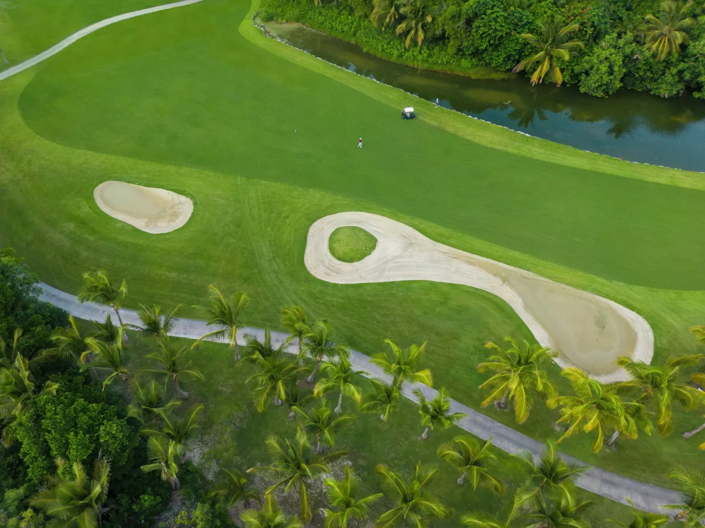 Overhead view of golf bunkers, palms, and a waterway at Iberostar Selection Bávaro Suites.