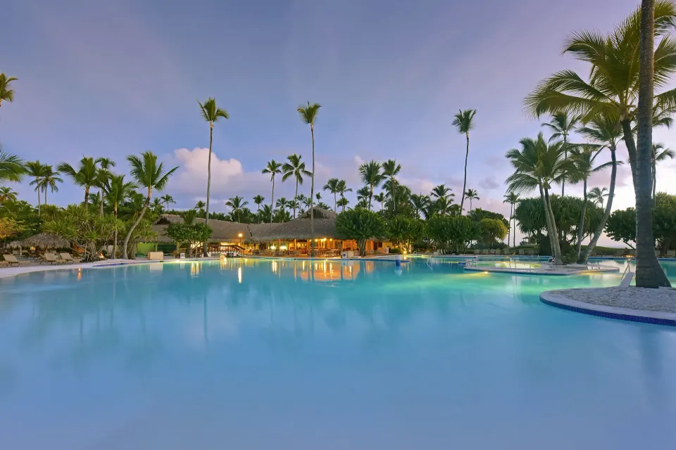 Palm-lined resort pool at dusk at Iberostar Selection Bávaro Suites.