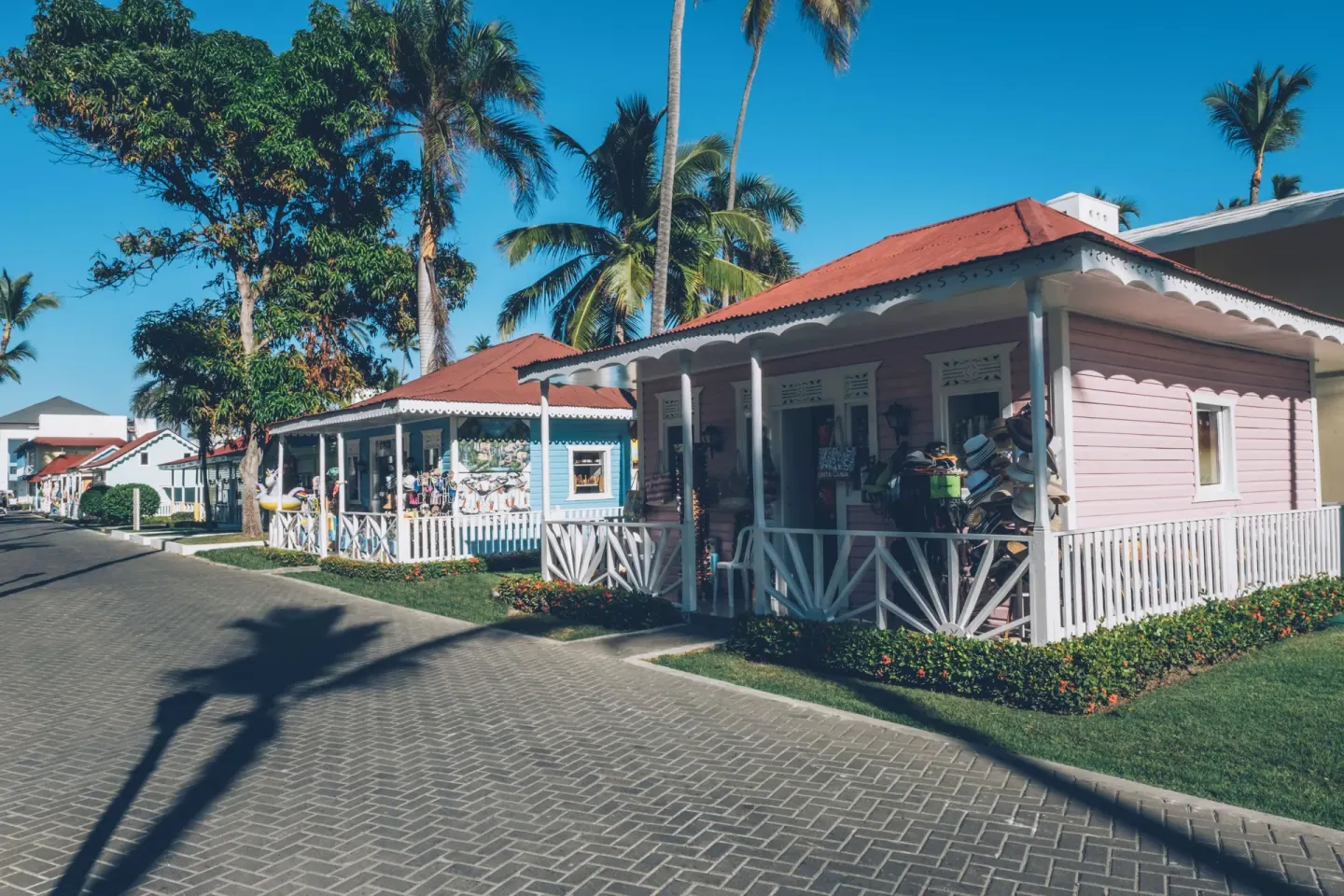 Pastel resort shop buildings along a palm-lined walkway at Iberostar Selection Bávaro Suites.