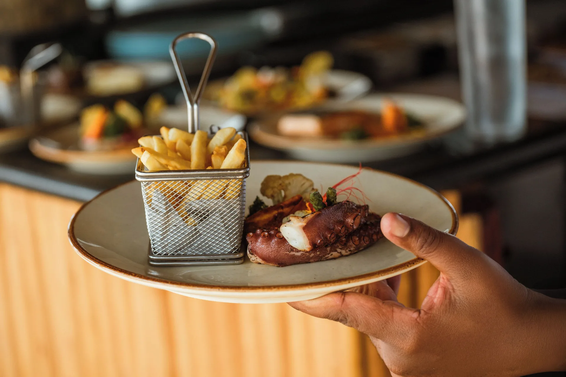 Plated seafood dish with fries being served at Iberostar Selection Bávaro Suites.