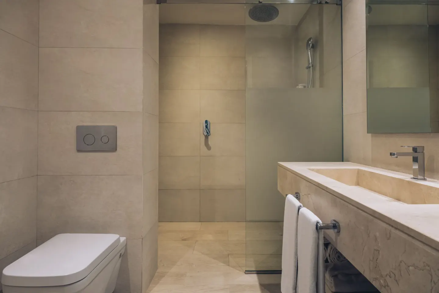 Junior Suite bathroom with shower, toilet, vanity, and mirror at Iberostar Selection Bávaro Suites.