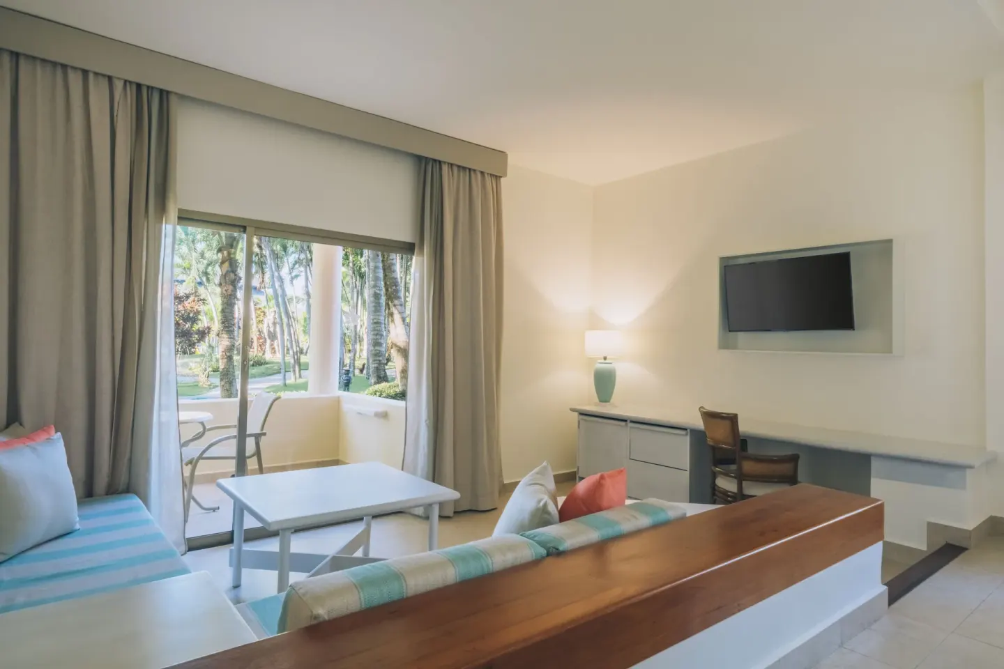 Junior Suite sitting area with terrace doors and TV at Iberostar Selection Bávaro Suites.