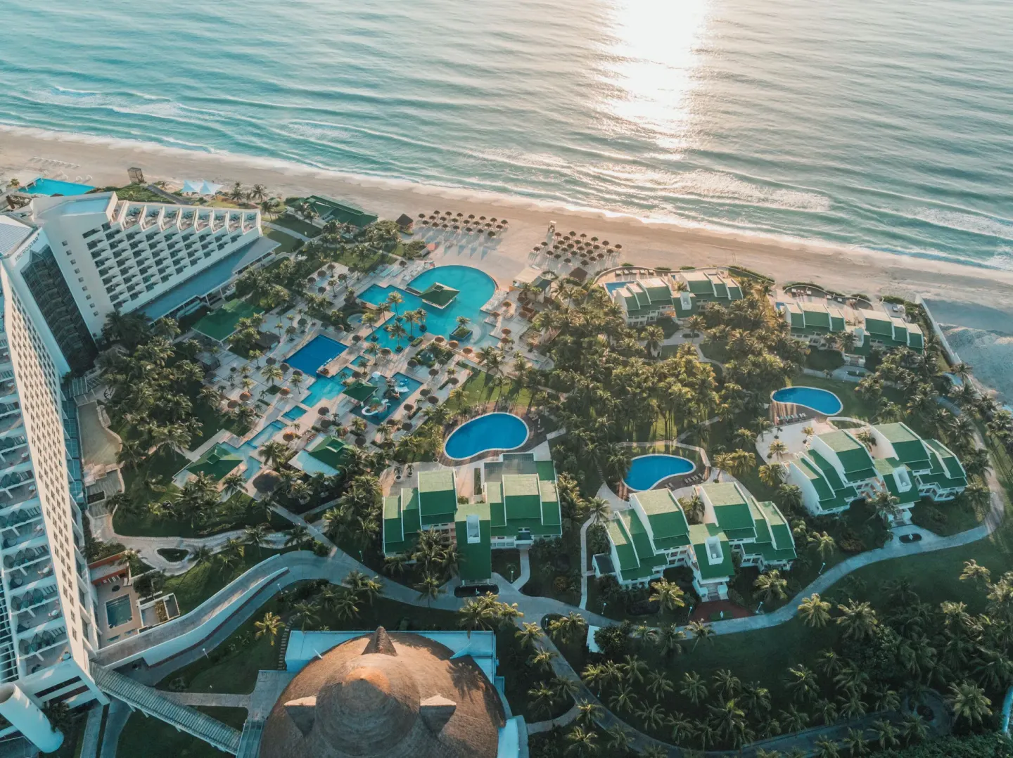 Aerial view of pools, gardens, resort buildings, beach, and ocean at Iberostar Selection Cancún.
