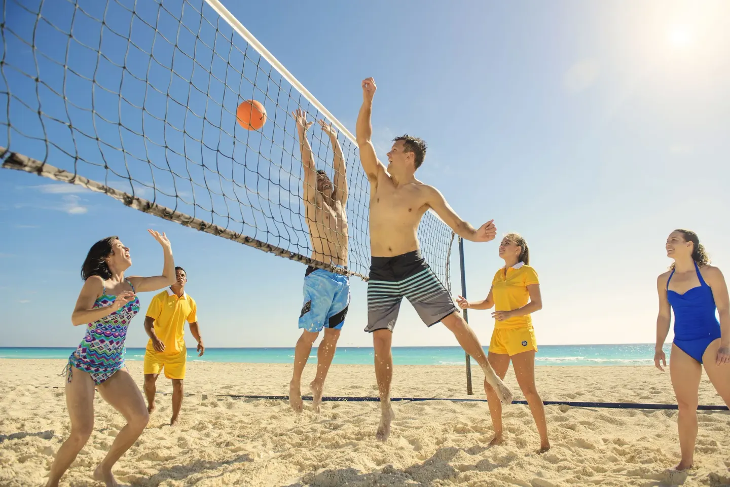 Guests playing beach volleyball by the sea at Iberostar Selection Cancún.