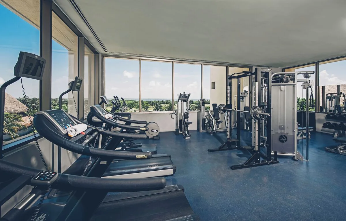Fitness room with treadmills, cardio machines, and weights at Iberostar Selection Cancún.