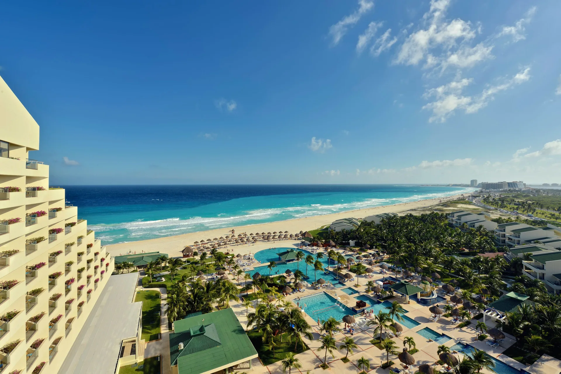 High view of pools, beach, and turquoise sea at Iberostar Selection Cancún.