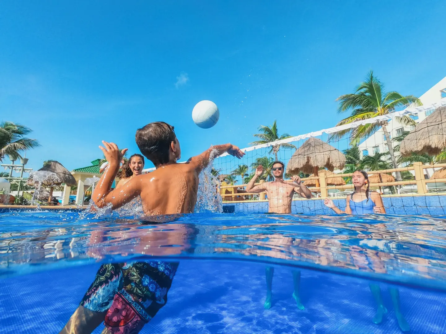 Guests playing volleyball in the resort pool at Iberostar Selection Cancún.