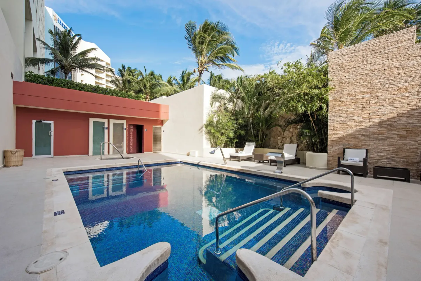 Quiet pool courtyard with loungers and palms at Iberostar Selection Cancún.