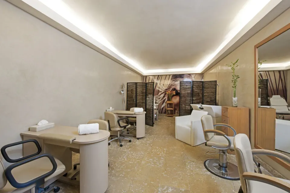 Salon and treatment room with chairs and privacy screens at Iberostar Selection Cancún.