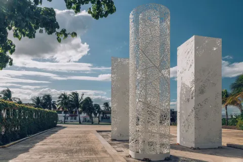 White sculptural entrance columns under a blue sky at Iberostar Selection Cancún.