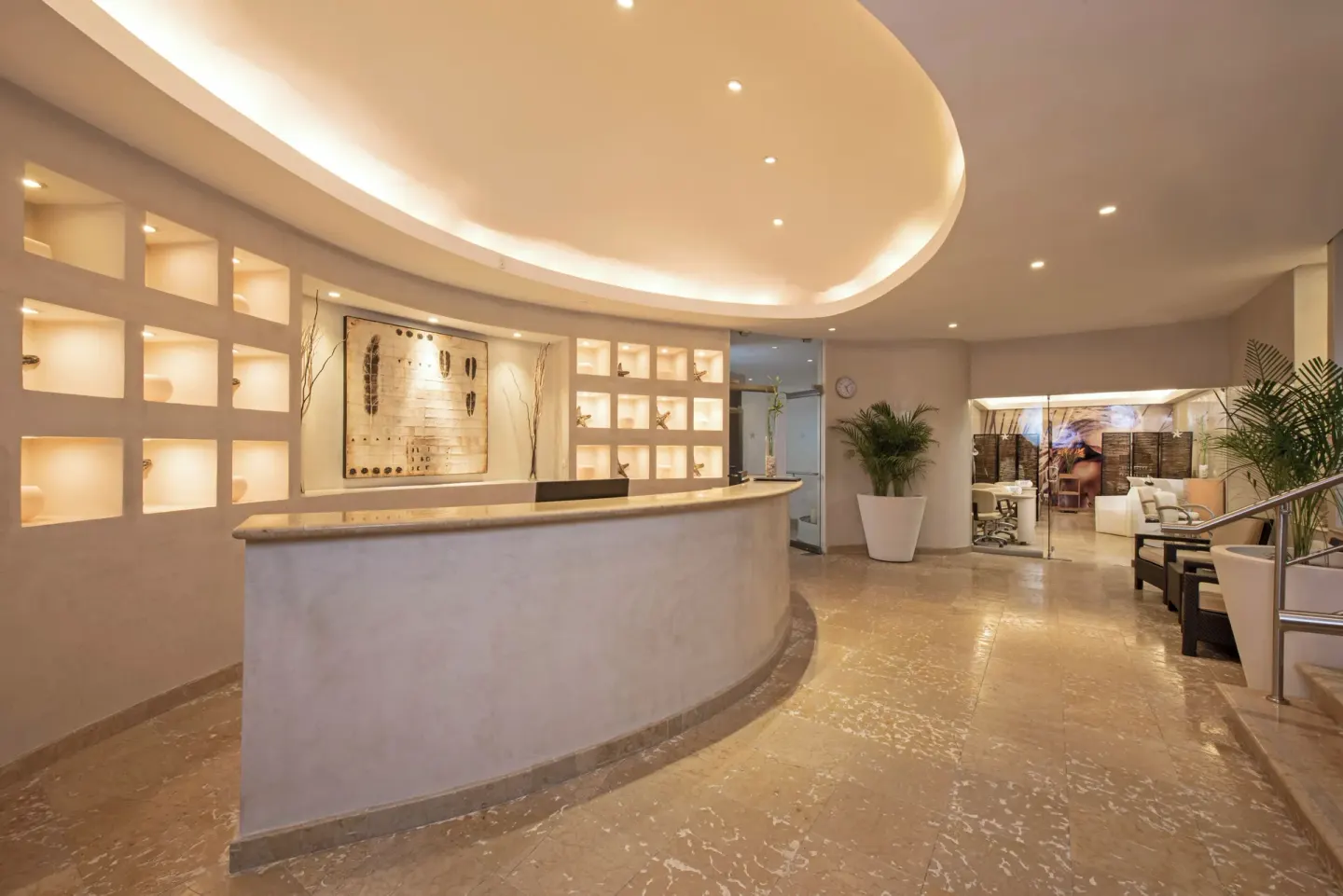 Spa reception desk with lit wall niches at Iberostar Selection Cancún.