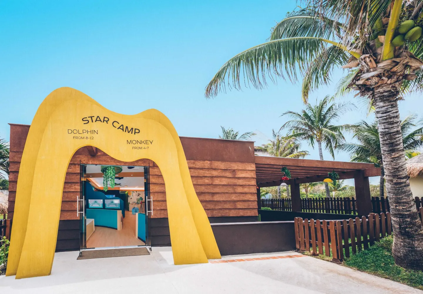 Star Camp entrance with yellow arch and palm trees at Iberostar Selection Cancún.