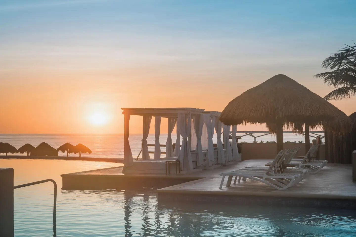 Sunrise over the pool deck and ocean at Iberostar Selection Cancún.