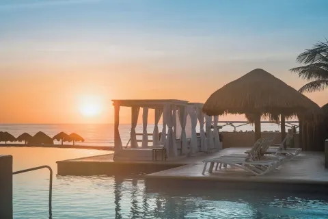 Sunrise over the pool deck and ocean at Iberostar Selection Cancún.