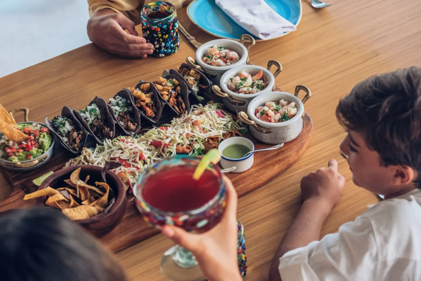 Mexican tacos, ceviche, chips, and drinks on a table at Iberostar Selection Cancún.
