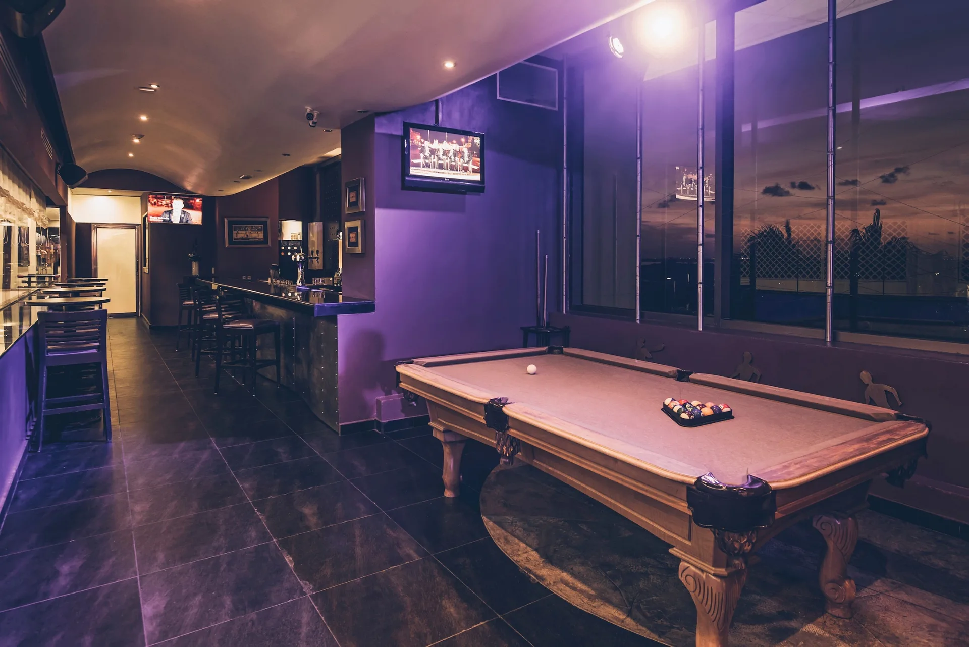 Sports bar with pool table, bar seating, and TVs at Iberostar Selection Cancún.
