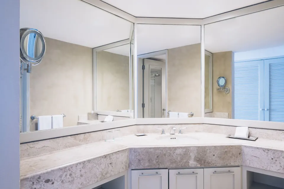 Premium Room bathroom vanity with wraparound mirrors at Iberostar Selection Cancún.