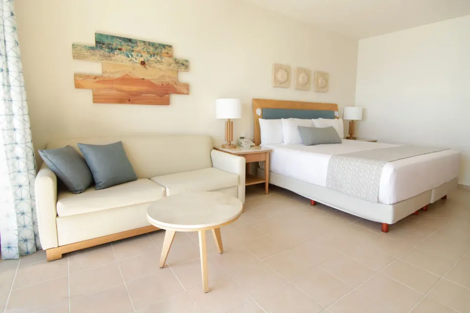 Premium Room seating area with king bed and sofa at Iberostar Selection Cancún.