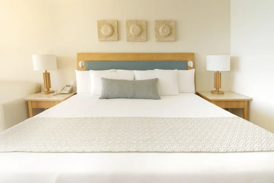 King bed with bedside lamps in a Premium Room at Iberostar Selection Cancún.
