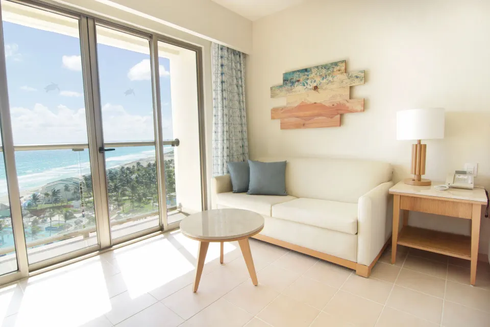 Premium Room sitting area with ocean-view balcony doors at Iberostar Selection Cancún.