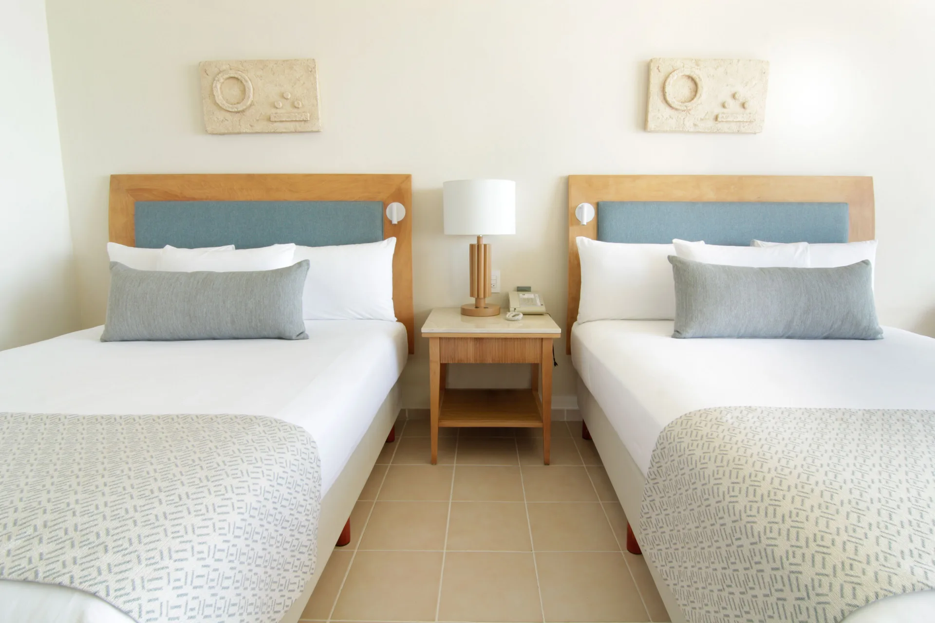 Standard Room with two beds, shared nightstand, and wall art at Iberostar Selection Cancún.