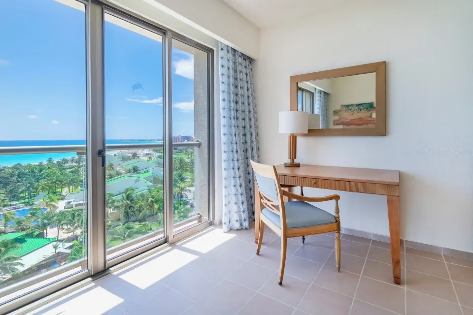 Suite Ocean View desk beside floor-to-ceiling windows at Iberostar Selection Cancún.