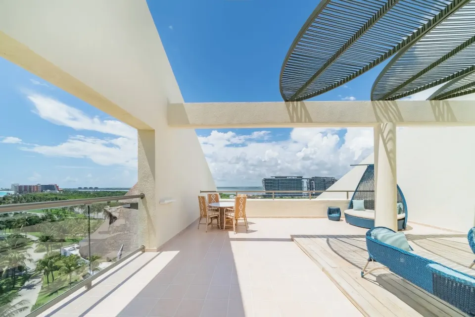 Suite Ocean View terrace with dining table and shaded seating at Iberostar Selection Cancún.