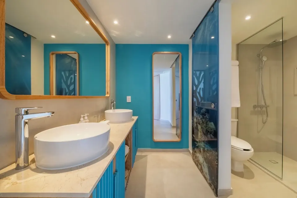 Oceanfront suite bathroom with double sinks and glass shower at Iberostar Selection Cancún.