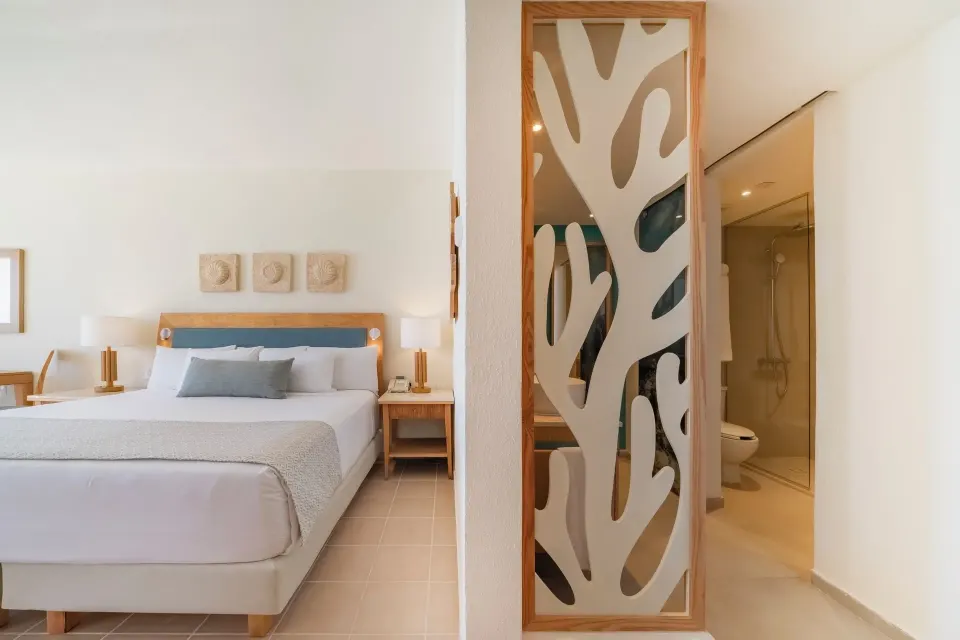 Oceanfront suite king bed and bathroom entry at Iberostar Selection Cancún.