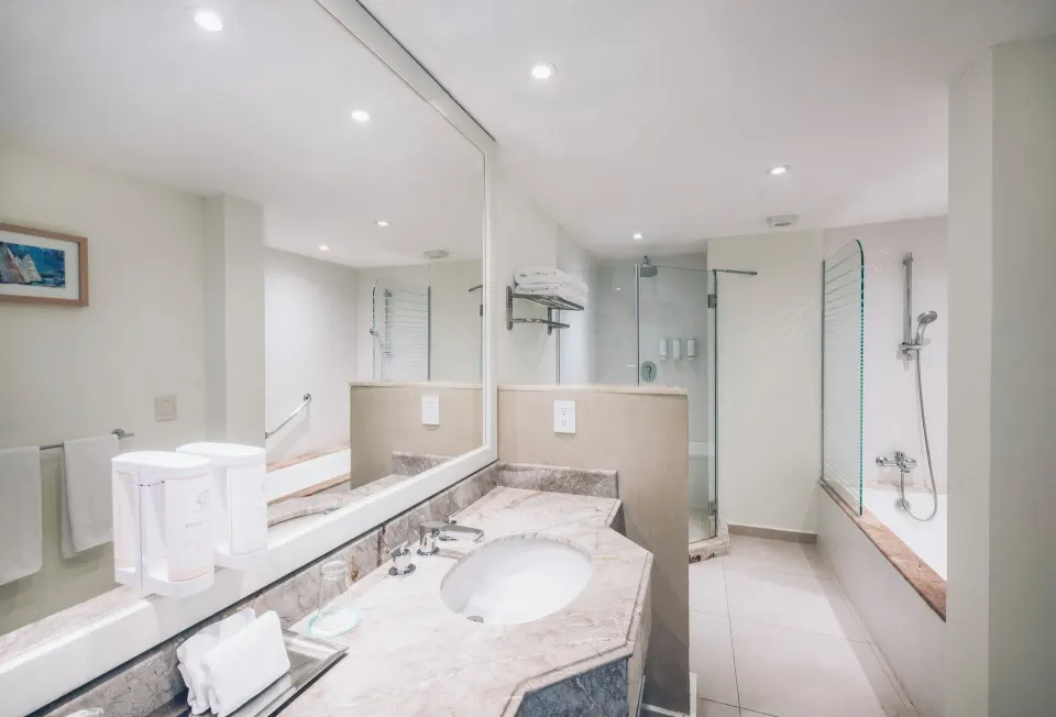 Villa oceanfront swim-out bathroom with vanity, shower, and tub at Iberostar Selection Cancún.