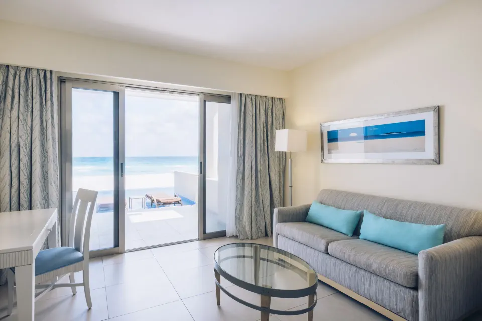 Oceanfront swim-out villa sitting area with sofa and terrace at Iberostar Selection Cancún.