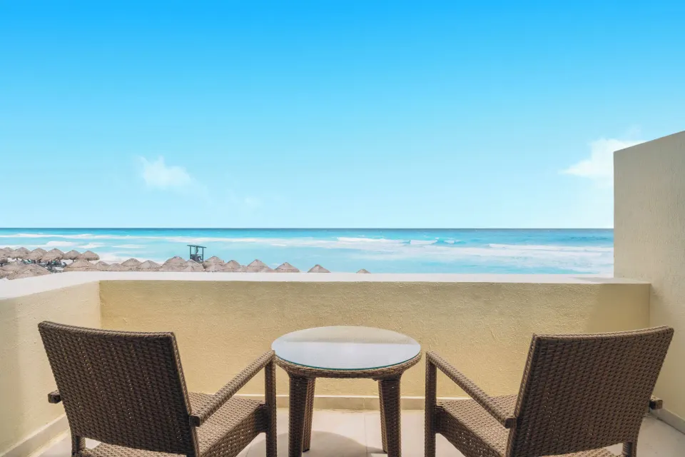 Oceanfront villa balcony with two chairs and sea view at Iberostar Selection Cancún.