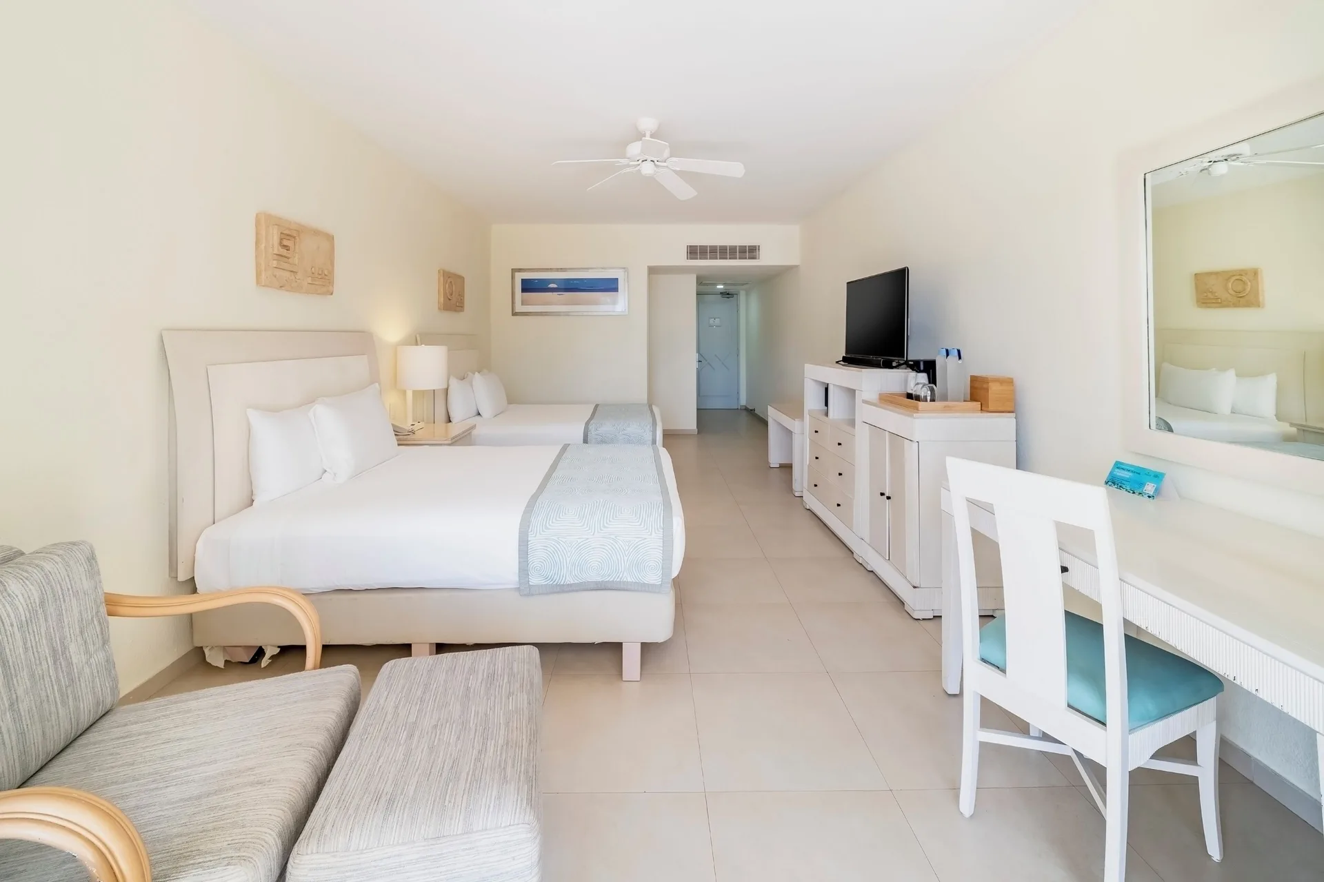 Villa Poolside room with two beds, seating, desk, and TV at Iberostar Selection Cancún.