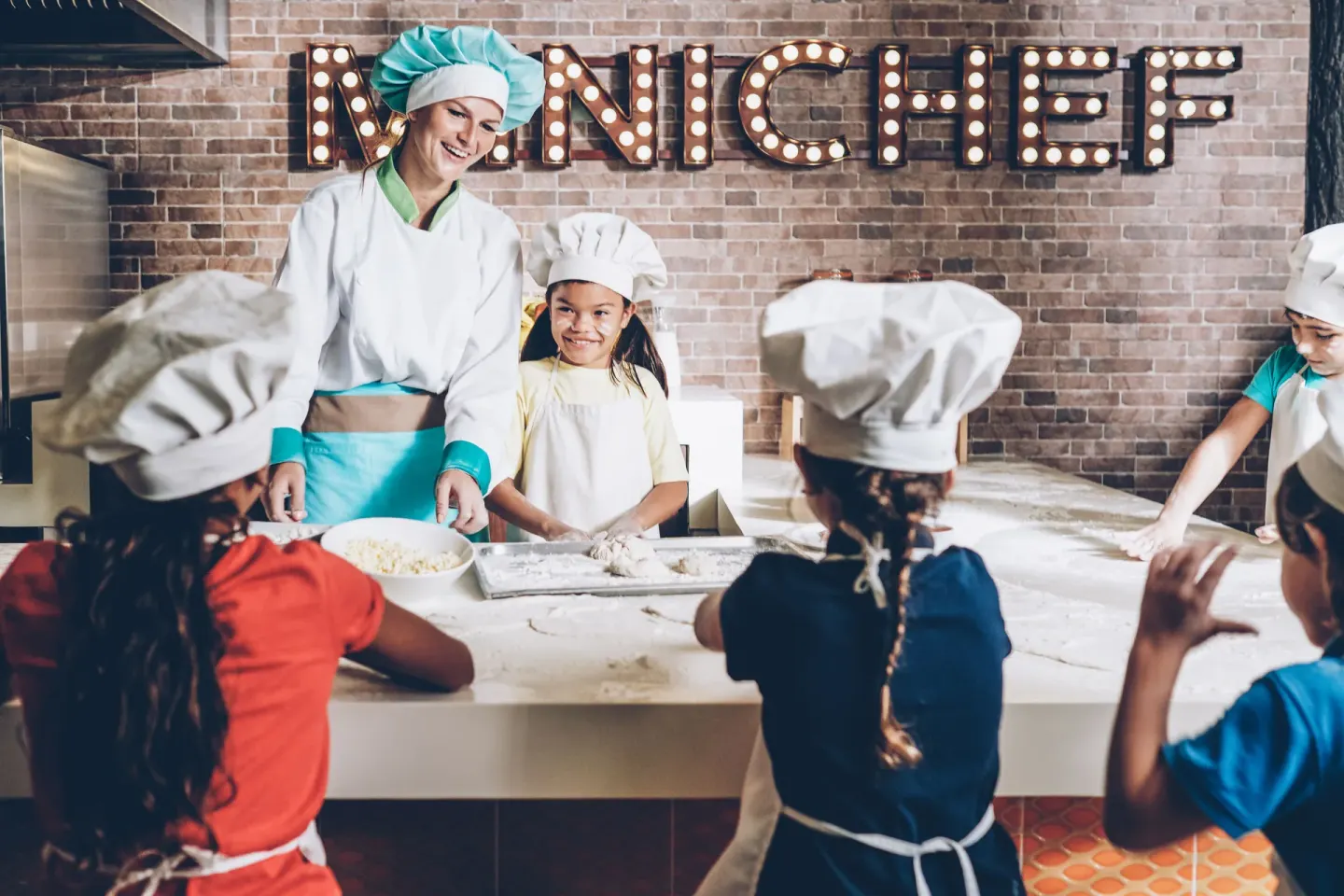 Children in chef hats at a cooking class at Iberostar Selection Coral Bávaro.