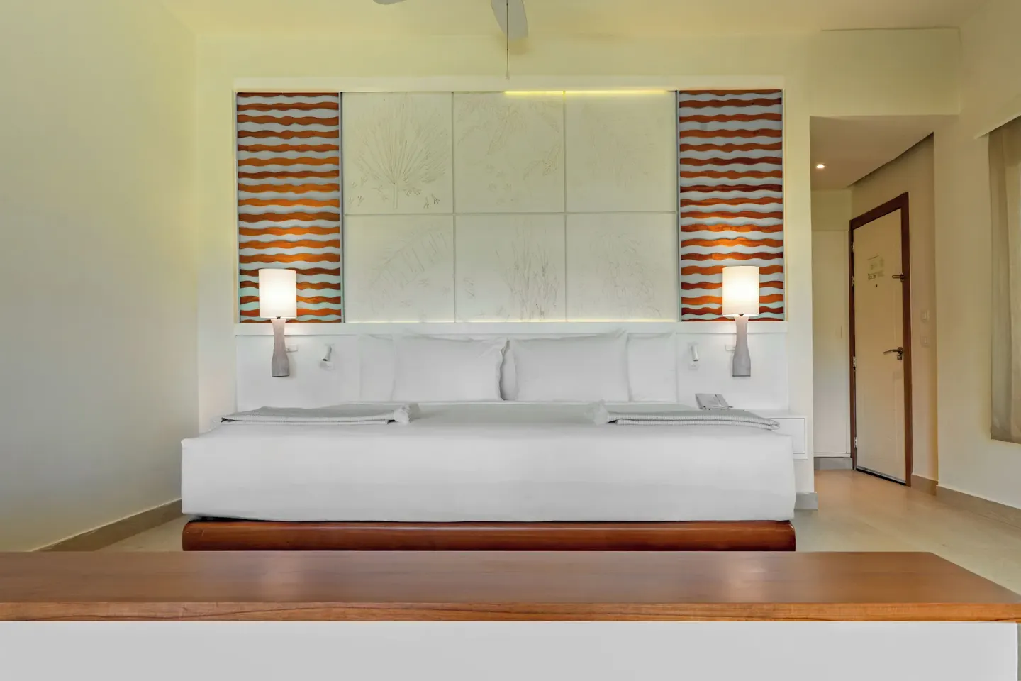 King bed with white linens and bedside lamps at Iberostar Selection Coral Bávaro.