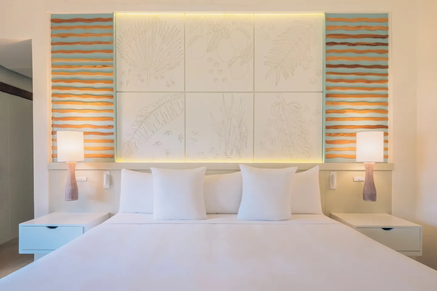 Guest room king bed with white linens and tropical wall panels at Iberostar Selection Coral Bávaro.