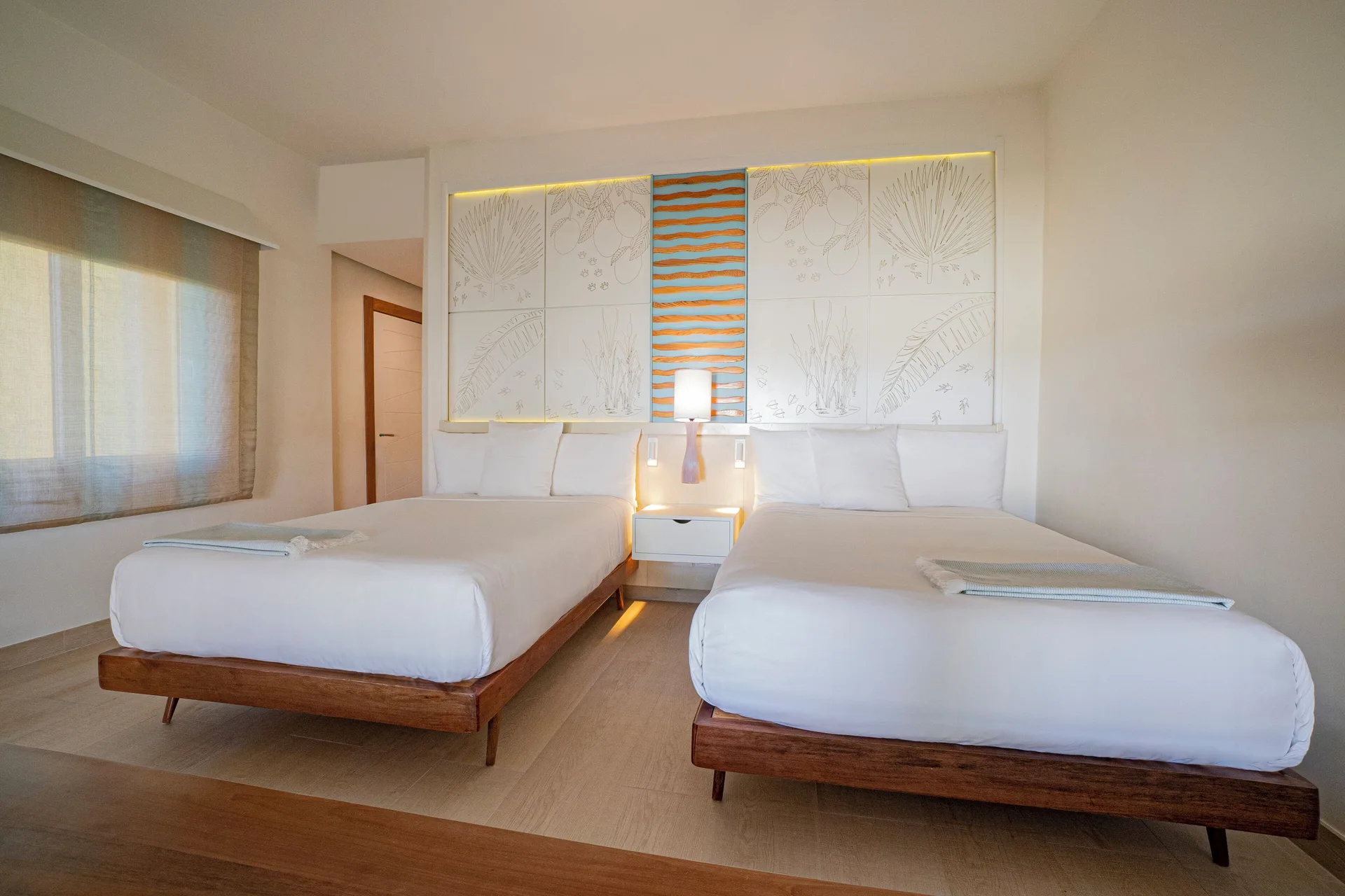 Guest room with two beds, white bedding, and wall art at Iberostar Selection Coral Bávaro.