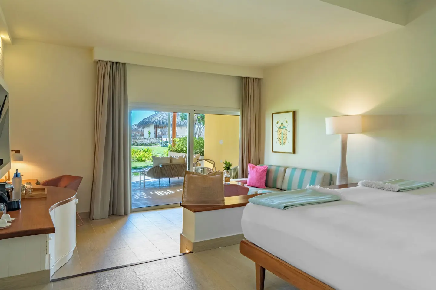 Bright guest room with king bed, sofa and patio at Iberostar Selection Coral Bávaro.