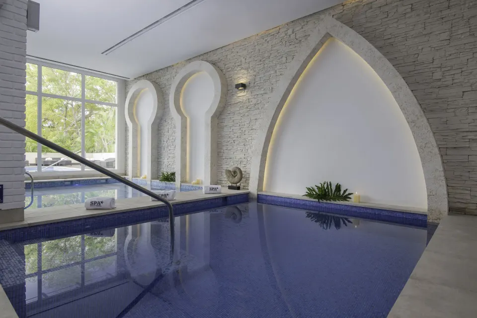 Indoor spa pool with arched stone walls at Iberostar Selection Coral Bávaro.